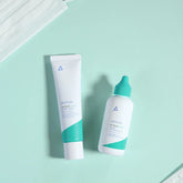 Two skincare products on a light green background