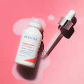 Aestura Theracare cream bottle with dropper on a pink background