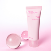 Pink tube of sunscreen with a matching cap on a pink background