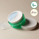 Green skincare jar with white lid on a beige background, featuring vegan and animal test-free logos.