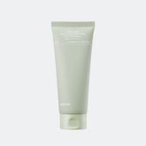 Green tube of skincare product on a light gray background