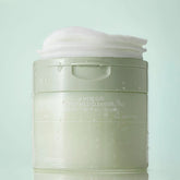 Cleansing pad container with white lid on a light green background
