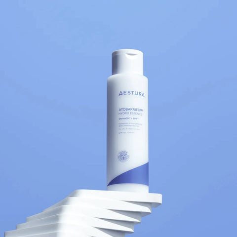 Aestura skincare bottle on a white platform with a blue background