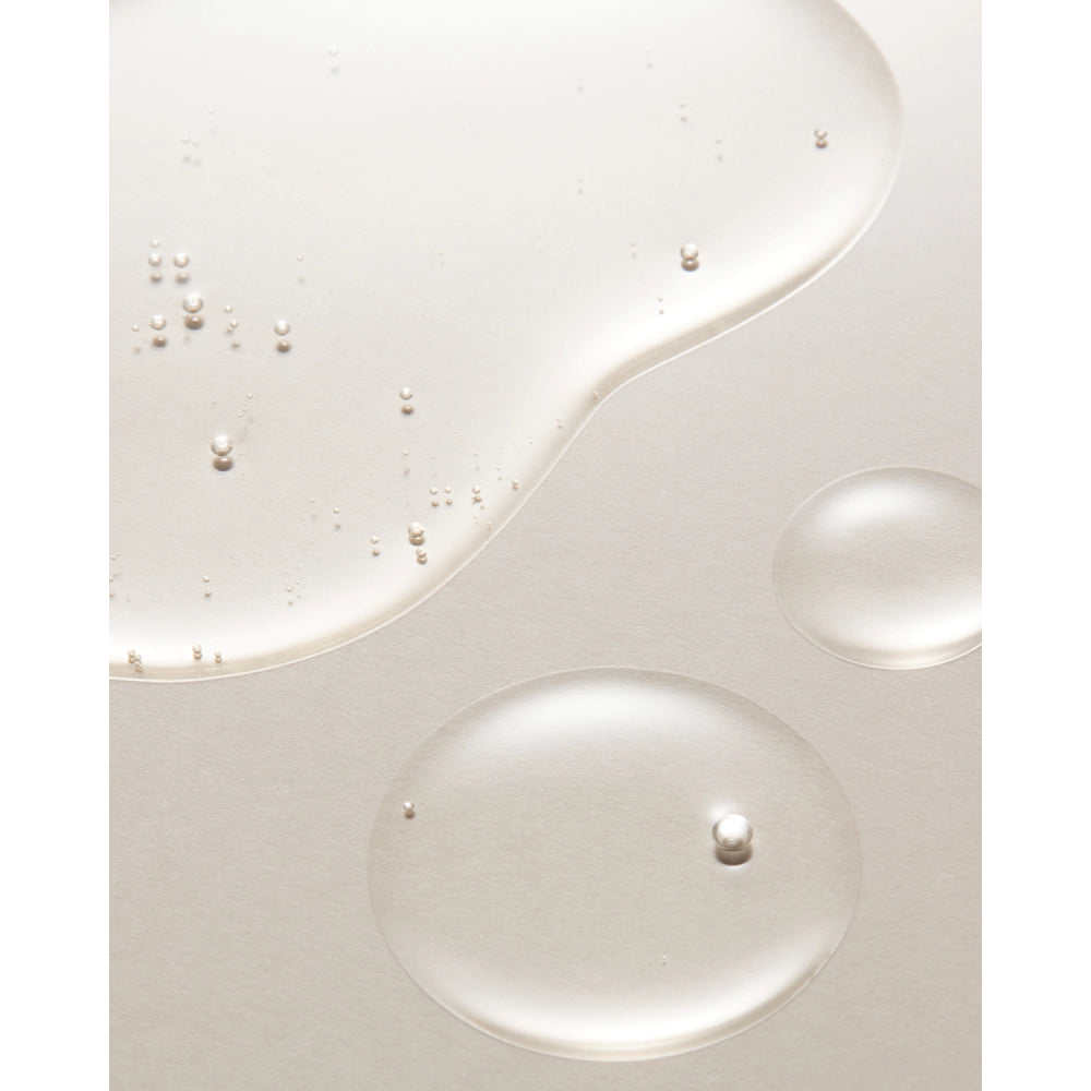 Close-up of a white surface with liquid droplets and bubbles