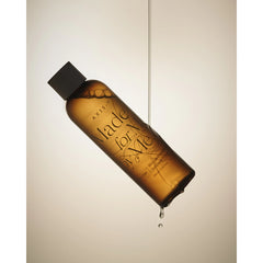 Amber bottle with black cap labeled 'AXE Made for Me' on a beige background