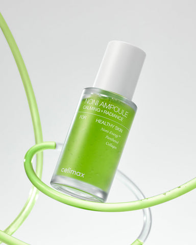 Green skincare bottle with white cap on a light gray background