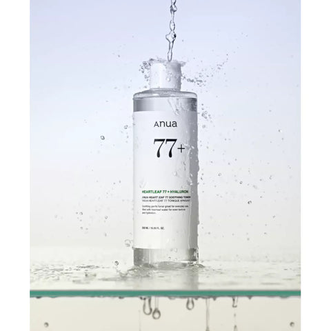 Anua skincare bottle with water droplets on a light gray background
