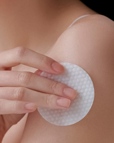 Person applying a adhesive patch to their skin with a hand