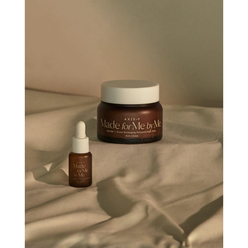 AXIS-Y skincare product set with jar and dropper on a soft fabric background