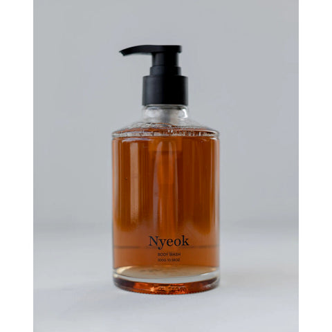 Bottle of Nyeok body wash with a pump on a light gray background