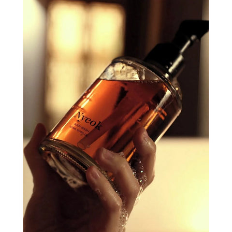 Hand holding a bottle of Nyeok skincare product with a blurred background