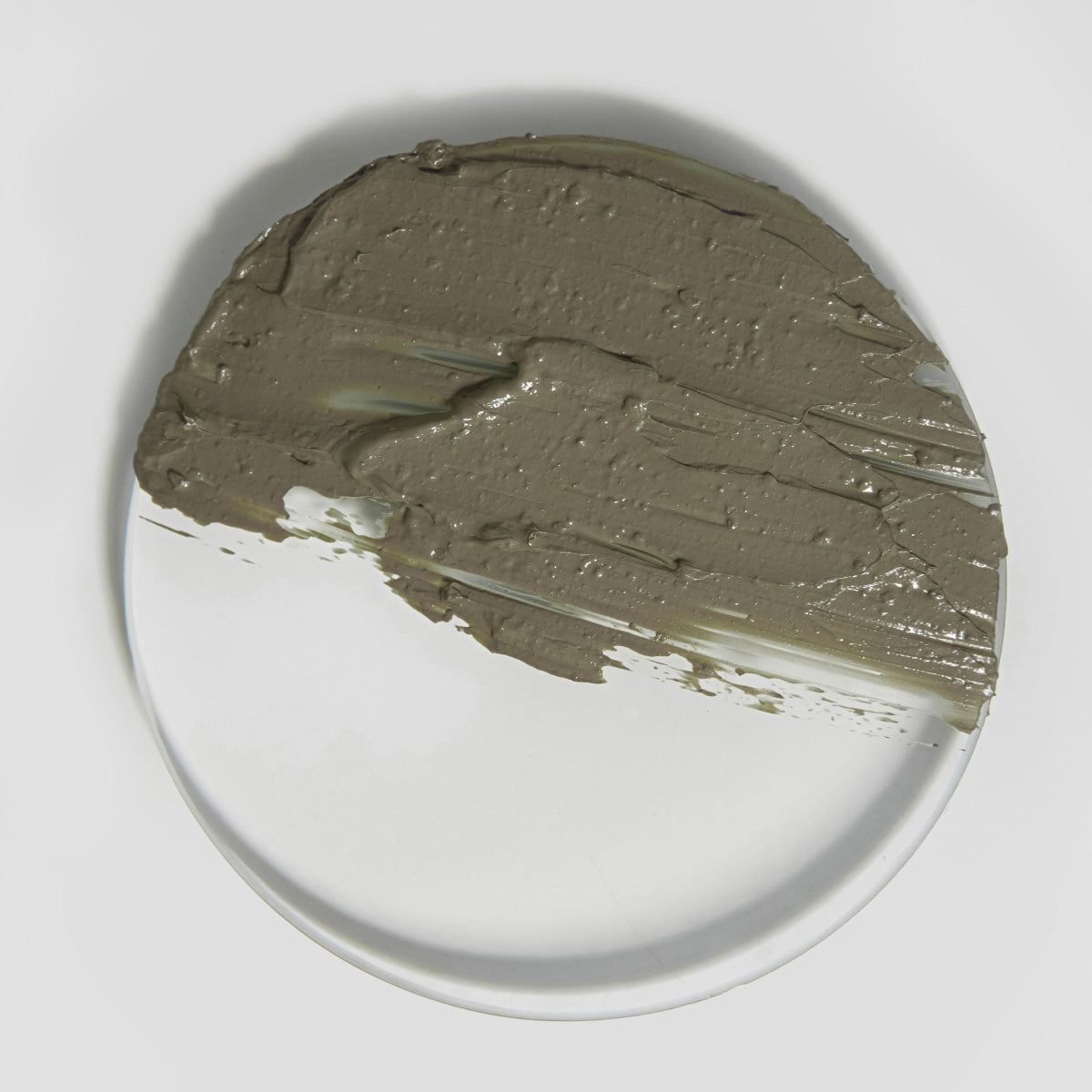 Gray clay on a white plate with a gray background