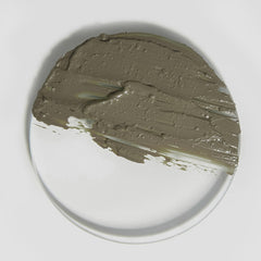 Gray clay on a white plate with a gray background