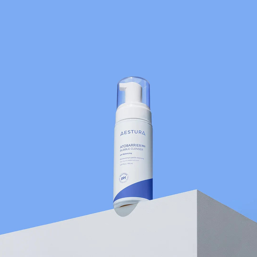 Skincare bottle with blue label on a white surface against a clear blue sky