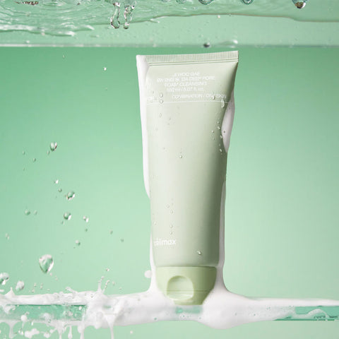Green skincare tube with water droplets and foam on a green background