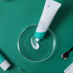 Two skincare tubes with a dropper on a green background