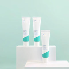 Three skincare products on a white stand against a light blue background