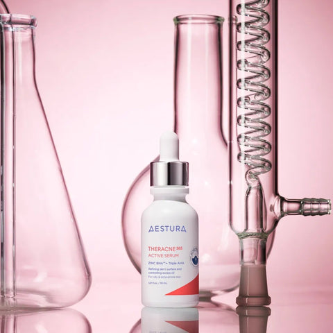 Skincare serum bottle labeled 'Aestura' with laboratory glassware on a pink background