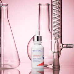 Skincare serum bottle labeled 'Aestura' with laboratory glassware on a pink background