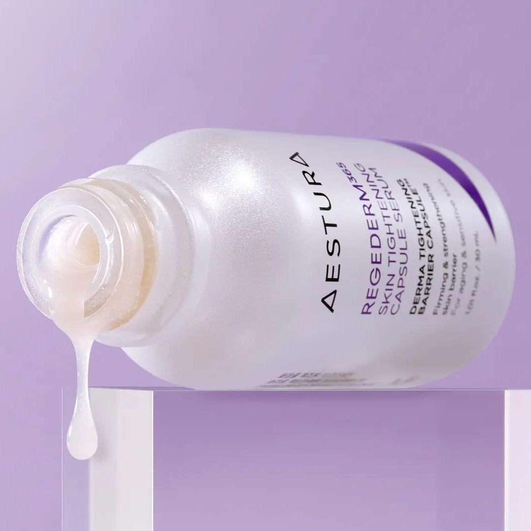 Aestura skincare bottle with product spilling out on a purple background