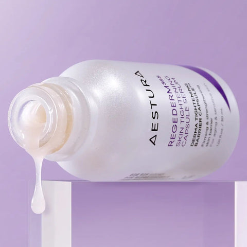 Aestura skincare bottle with product spilling out on a purple background
