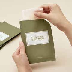 Mugwort sheet mask packaging with a hand lifting the corner on a beige background