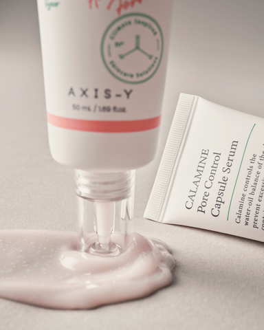 Axis-Y skincare product with a tube of Calamine Pore Control Capsule Serum on a neutral background