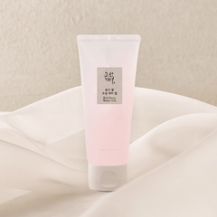 Pink tube of skincare product on a beige fabric background