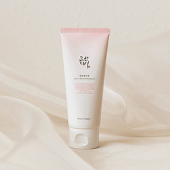 Tube of skincare product with visible brand name on a beige background