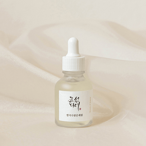 Skincare dropper bottle with a white label on a beige background