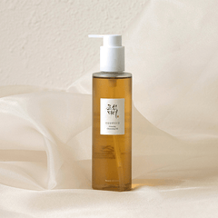 Bottle of cleansing oil with a pump on a soft beige background