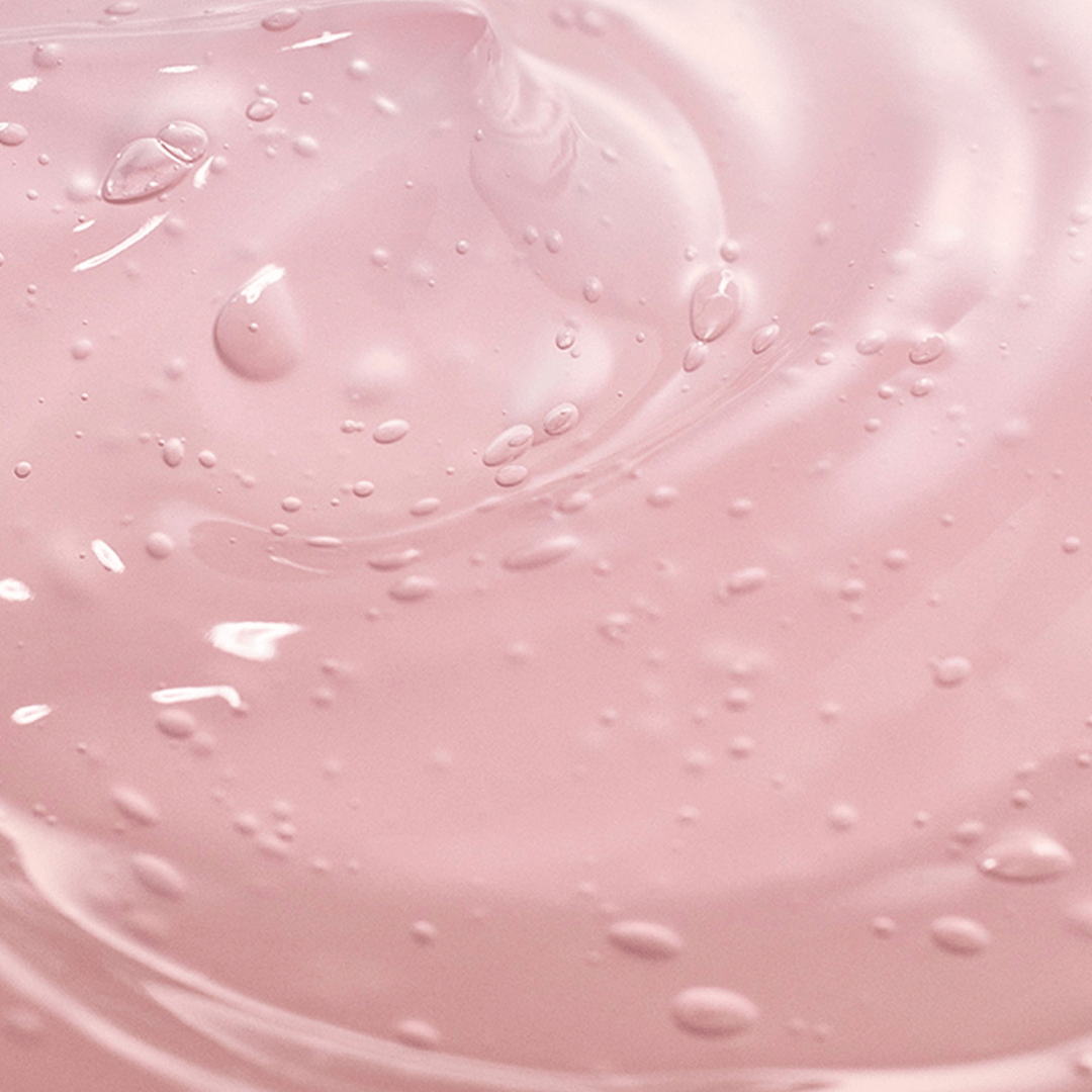 Close-up of pink liquid with droplets and swirls