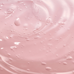 Close-up of pink liquid with droplets and swirls