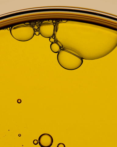 Close-up of oil and water layers with bubbles on a beige background