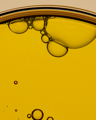 Close-up of oil and water layers with bubbles on a beige background