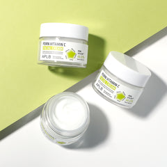 Three jars of 'Porn Vitamin C' cream on a green and white background