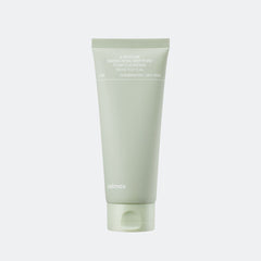 Green tube of skincare product on a light gray background