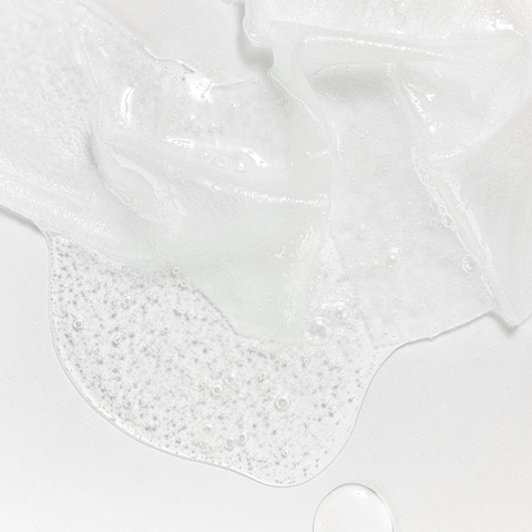 Close-up of white slime with bubbles on a light gray background