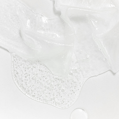 Close-up of white slime with bubbles on a light gray background