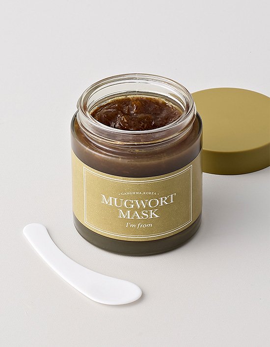 Jar of Mugwort Mask with a white spatula on a light gray background