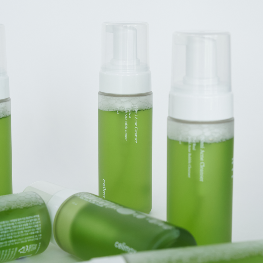 Green skincare bottles with white caps on a light gray background