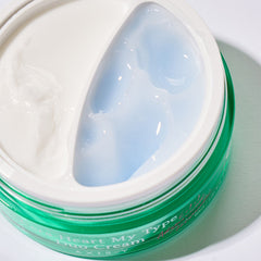 Green jar of cream with a heart-shaped applicator on a white background