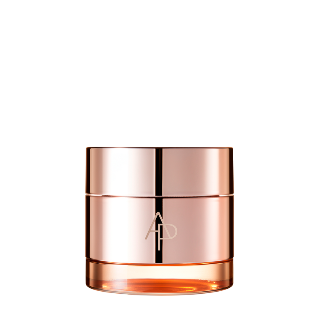 Rose gold cosmetic jar with a brand logo on a white background