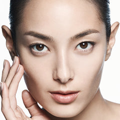 Close-up of a person's face with a neutral expression on a white background