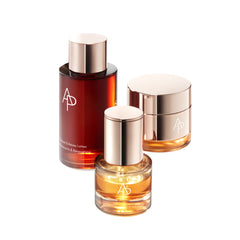 Three skincare bottles with gold caps and a visible brand logo on a white background