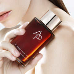 Perfume bottle with a logo held by a person, close-up shot.