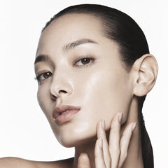 Close-up of a woman's face with a neutral expression on a white background