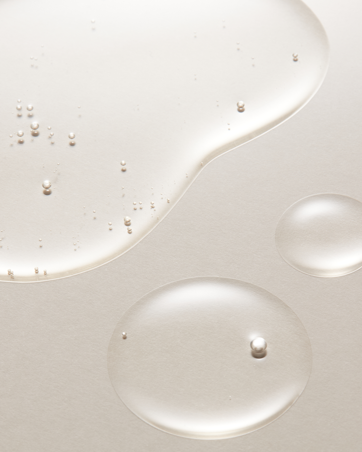 Close-up of white liquid with small bubbles on a light gray background