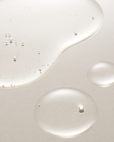 Close-up of white liquid with small bubbles on a light gray background