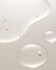 Close-up of white liquid with small bubbles on a light gray background